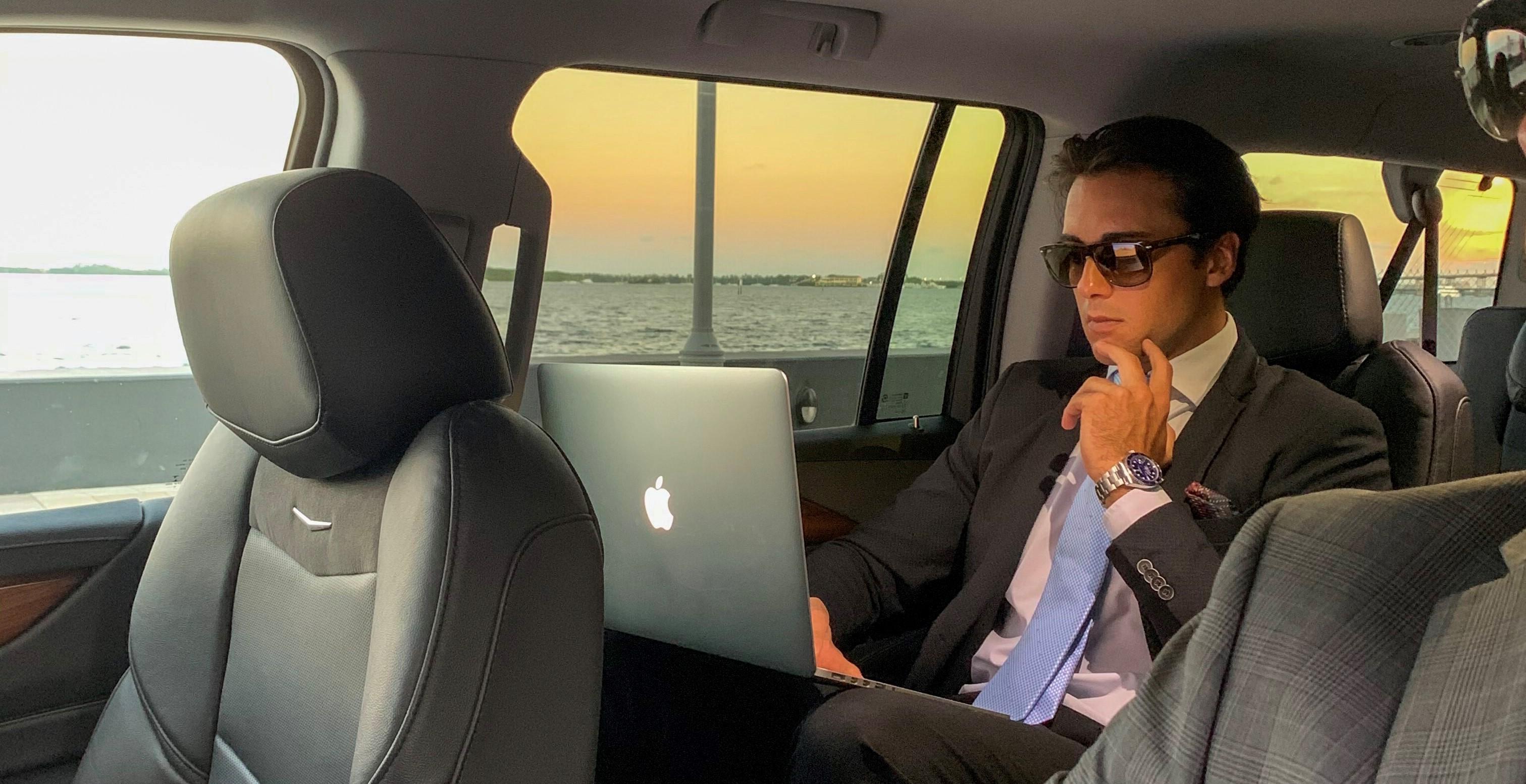 Businessman holding a laptop inside a limo